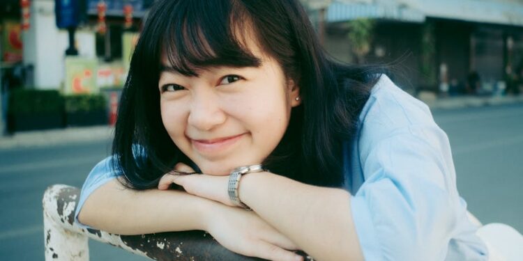 Cheerful young woman smiling outdoors in Chiang Mai, Thailand. Bright and joyful portrait.