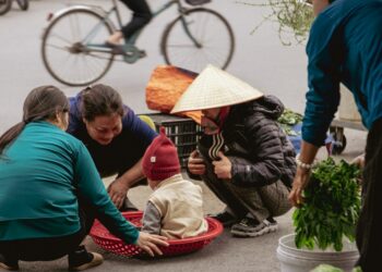 People gathered around a child in a basket at market