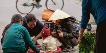 People gathered around a child in a basket at market