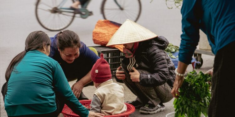 People gathered around a child in a basket at market