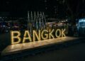 a sign that says bangkok lit up at night