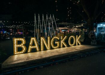 a sign that says bangkok lit up at night