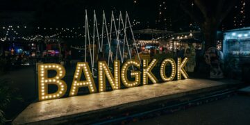 a sign that says bangkok lit up at night