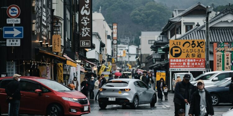 a group of people walking down a street next to tall buildings
