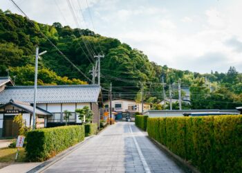 A picturesque road leads to a lush green hill.