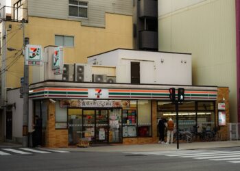 Candid street photo of a 7-Eleven convenience store in Japan.
