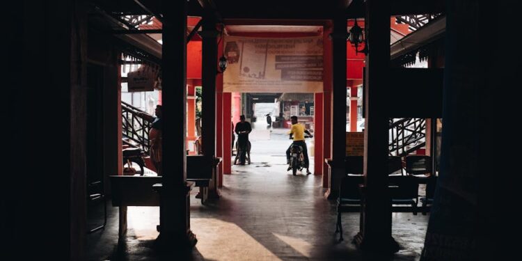 Shadowy market passageway with people in Terengganu, Malaysia.