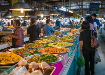 Explore the bustling atmosphere of a Bangkok street market with colorful Thai cuisine.