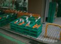 Vibrant street market in Tokyo showcasing fresh oranges in colorful crates.
