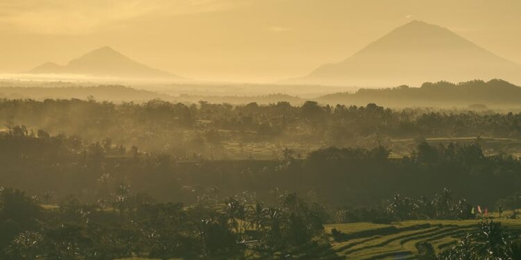 Stunning sunrise view of Bali's rice terraces and mountains, capturing Indonesia's natural beauty.