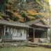 Explore a serene traditional Japanese house surrounded by vibrant autumn foliage, capturing the essence of rural Japan.