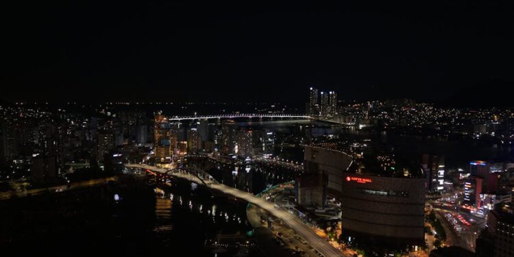 A stunning view of Busan skyline at night with Gwangan Bridge illuminating the cityscape.