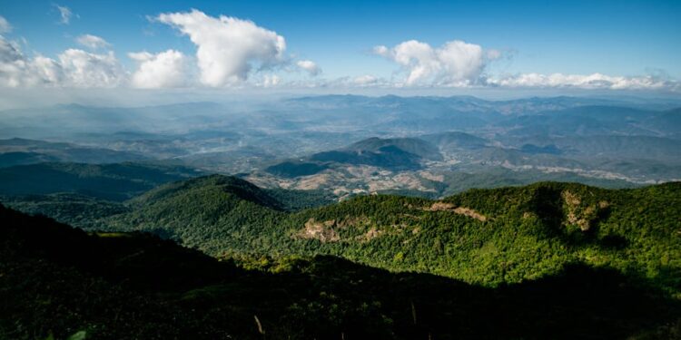 Expansive view of lush green mountains and clouds in Chiang Mai, Thailand.