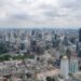 Stunning aerial view of Bangkok's modern skyline under clouded skies.