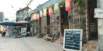 A vibrant Hanoi street with an art studio, colorful lanterns, and local shops.