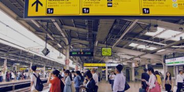 Commuters at a bustling train station in Tokyo, Japan, waiting for their train.