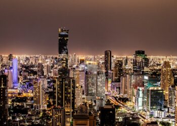 A vibrant night view of Bangkok's illuminated skyline featuring modern skyscrapers.