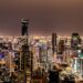 A vibrant night view of Bangkok's illuminated skyline featuring modern skyscrapers.