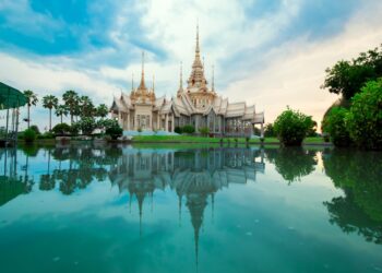 Beautiful Thai temple with serene reflection in water, showcasing spirituality and culture.