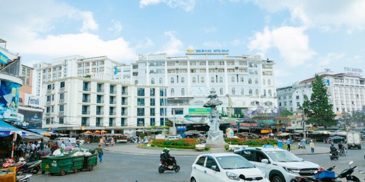 Vibrant street scene in Đà Lạt, Vietnam, showcasing hotels, traffic, and city life under a clear sky.
