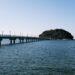 A serene ocean view featuring a bridge leading to an island in Gamagōri, Japan.