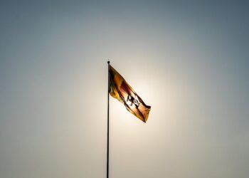 The Sri Lankan flag waves majestically in front of a bright sun in Colombo.