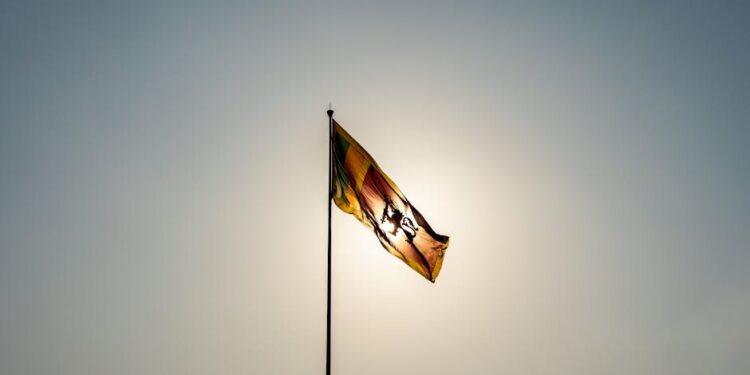 The Sri Lankan flag waves majestically in front of a bright sun in Colombo.