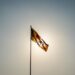The Sri Lankan flag waves majestically in front of a bright sun in Colombo.