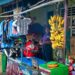 Colorful market stall in Banten, Indonesia with bananas, clothes, and a man.