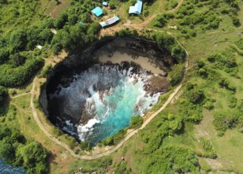 A breathtaking aerial view of Angel's Billabong in Nusa Penida, Bali showcasing vibrant turquoise waters in a rocky inlet.