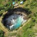 A breathtaking aerial view of Angel's Billabong in Nusa Penida, Bali showcasing vibrant turquoise waters in a rocky inlet.