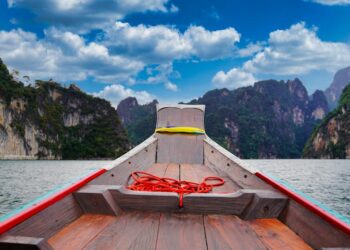 A peaceful boat ride through the scenic limestone cliffs of Khao Sok National Park, Thailand.
