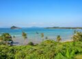 A stunning view of Ko Mak's tropical beach with clear blue waters and palm trees.