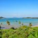 A stunning view of Ko Mak's tropical beach with clear blue waters and palm trees.