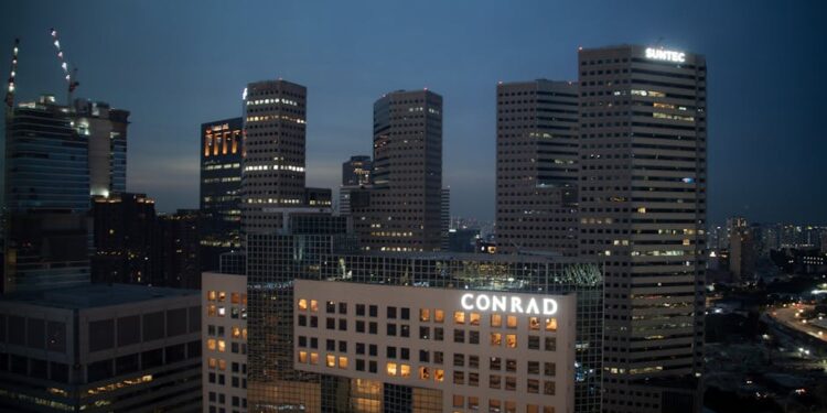 Evening view of Singapore's skyline with prominent Conrad and Suntec buildings, captured at dusk.