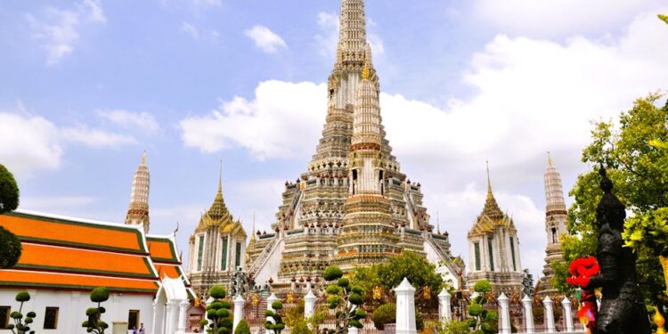 Beautiful architectural view of Wat Arun temple against blue sky in Bangkok, Thailand.