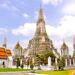 Beautiful architectural view of Wat Arun temple against blue sky in Bangkok, Thailand.