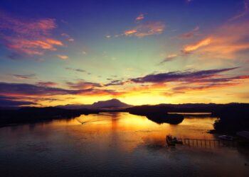 Mesmerizing sunset over a river in Tuaran, Sabah, Malaysia with vibrant sky and reflections.