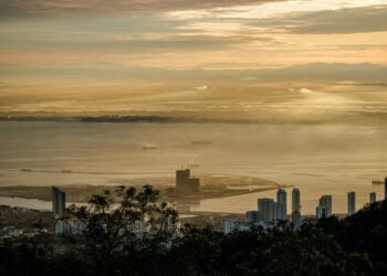 Stunning sunrise view over Penang from Bukit Bendera, Malaysia featuring skyscrapers and the coastline.