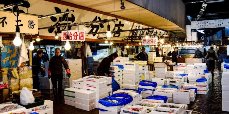 A vibrant scene at the Tsukiji Fish Market showcasing fresh seafood and active vendors in Tokyo, Japan.