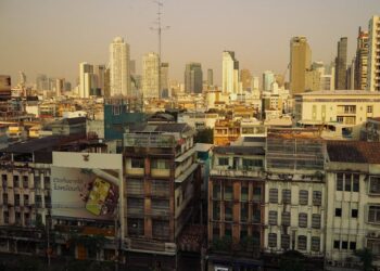 Sunset view of Bangkok's skyline showcasing modern skyscrapers and historic buildings.