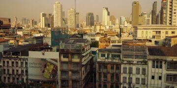 Sunset view of Bangkok's skyline showcasing modern skyscrapers and historic buildings.