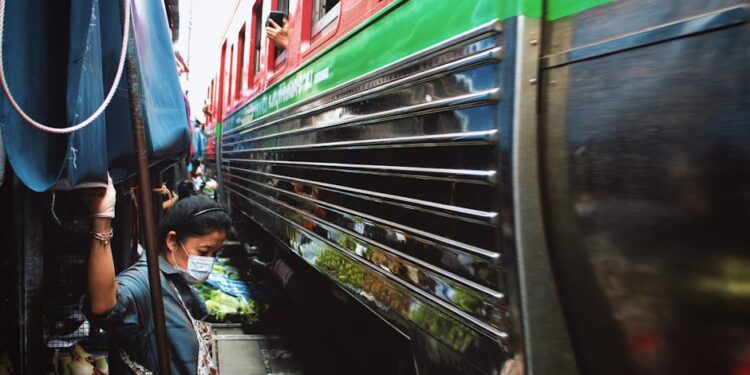Experience the bustling Maeklong Railway Market in Bangkok with a train passing by closely.