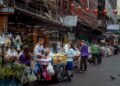 Vibrant street market scene in Asia with diverse vendors selling fresh produce.