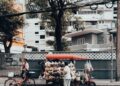 Street vendor with a cart selling goods on a city street in Bangkok, Thailand, showcasing local urban life.