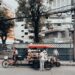 Street vendor with a cart selling goods on a city street in Bangkok, Thailand, showcasing local urban life.